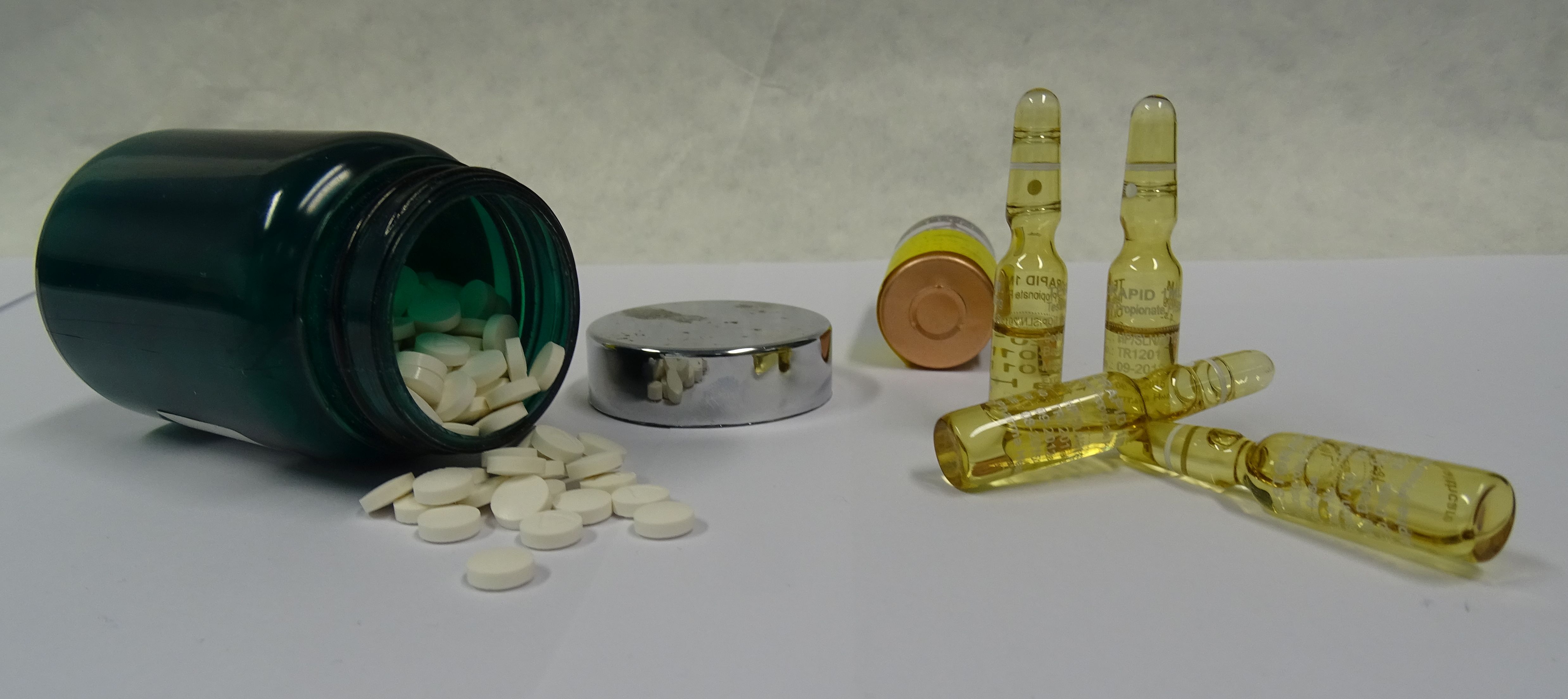 Die Abbildung zeigt beispielhaft Tabletten und Ampullen mit Injektionsölen, die als Dopingstoffe zur (illegalen) Steigerung der körperlichen Leistungsfähigkeit genommen werden.